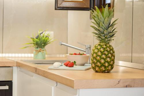 eine Ananas auf einer Küchentheke mit einer Schale Obst in der Unterkunft Villa Sunrise by the Sea in Kiotari