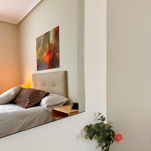 a bedroom with a bed and a painting on the wall at La casa de siempre in Alba de Tormes