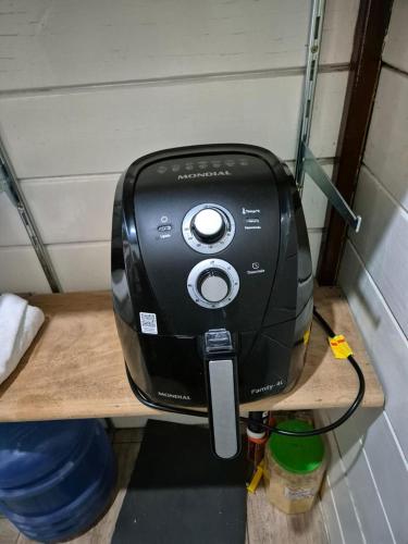 a black coffee maker sitting on a wooden shelf at Casa Raízes - Atibaia in Atibaia