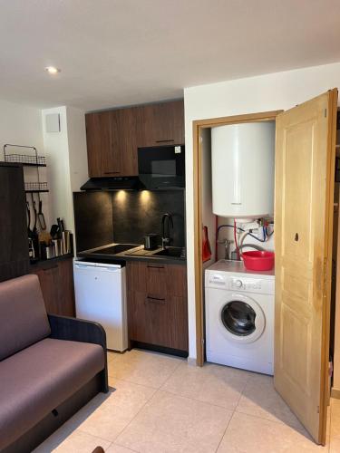 une cuisine avec un lave-linge et un lave-linge dans l'établissement La neige dorée - front de neige, à Montgenèvre