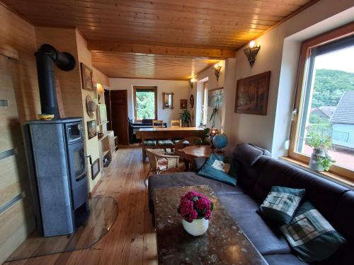 - un salon avec un canapé et une cuisinière dans l'établissement Maison 20' COLMAR Jardin Calme Chevaux Vue, à Jungholtz