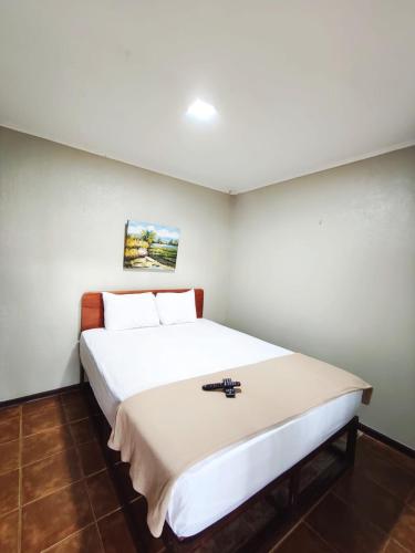 a bedroom with a large white bed in a room at Ávita Lodge in Quesada