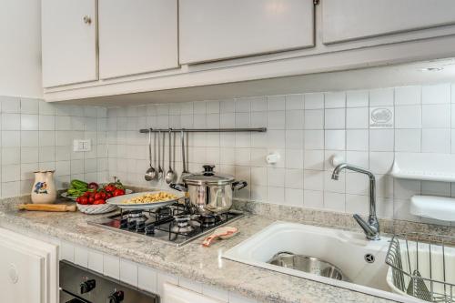 een aanrecht met een fornuis en een wastafel bij U Quardianu - Le Case di Valentina in Gallipoli