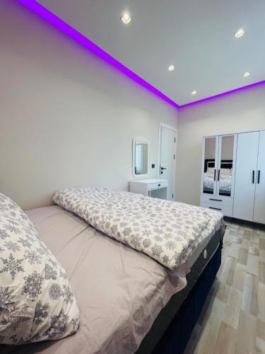 1 dormitorio con 1 cama grande con iluminación púrpura en Amora Suites, en Estambul