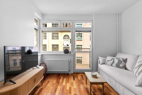 a living room with a couch and two windows at Cozy Studio in City Centre in Helsinki