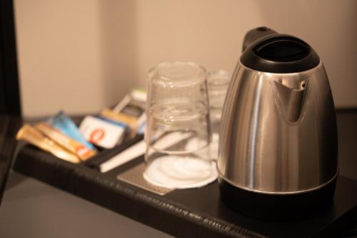 a tea kettle and a glass on a table at Meg Lifestyle Hotel & Apartaments in Riccione