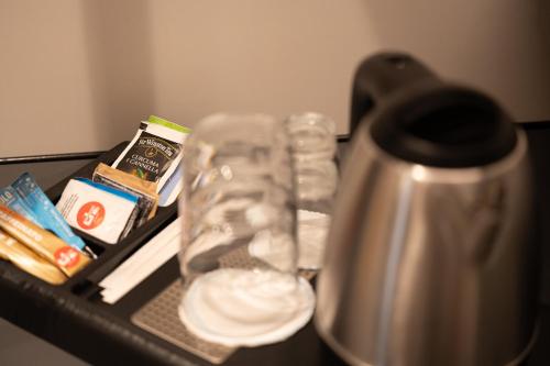 a table with a drinking glass and a coffee maker at Meg Lifestyle Hotel & Apartaments in Riccione