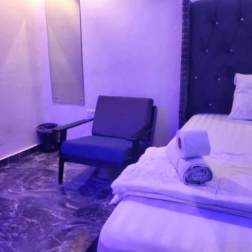 a room with a chair and a bed and a mirror at WELTONS Apartment BABA YUSUF in Ikeja
