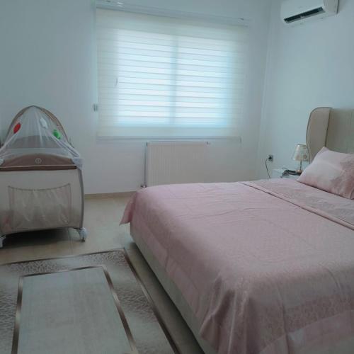 a bedroom with a large bed and a window at Chez Lina Folla in Monastir