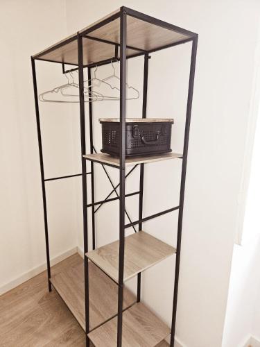 a black book shelf with two baskets on it at Alcamim Guesthouse in Elvas