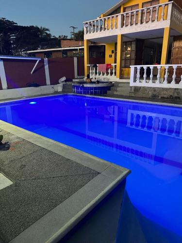 a large blue swimming pool in front of a building at Casa de descanso con piscina Chachagüi in Chachagüí