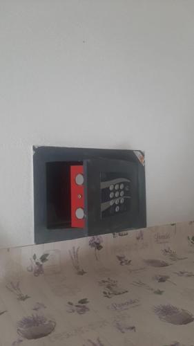 a microwave with a red and white button on a wall at Civico 381 - private parking in Quartu SantʼElena