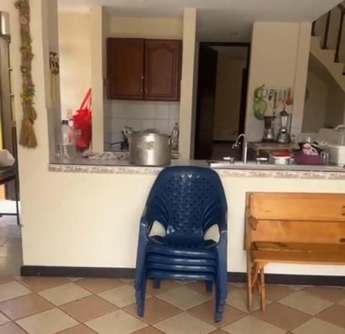 a blue chair sitting in front of a kitchen counter at Casa de descanso con piscina Chachagüi in Chachagüí