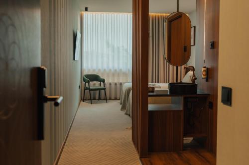 a hotel room with a bed and a mirror at Hotel Leiriartem by Grupo Quinta dos Lagos in Leiria