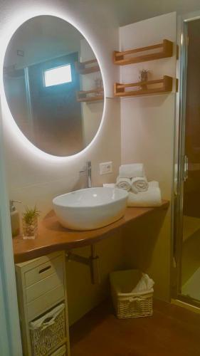 a bathroom with a white sink and a mirror at Civico 381 - private parking in Quartu SantʼElena