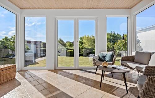 LøgstørNice Home In Løgstør With Wifi的带窗户、沙发和桌子的客厅
