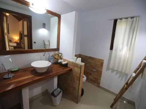 uma casa de banho com um lavatório, um espelho e um WC. em Laguna Gili em Gili Trawangan