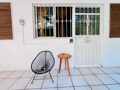 a chair and a table in front of a door at Palmar la Punta 1 Starlink 2min walk to the beach in Brisas de Zicatela