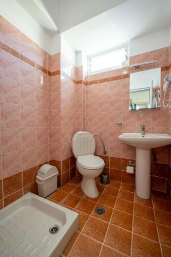 a bathroom with a toilet and a sink and a tub at Classic Rooms in Sarandë