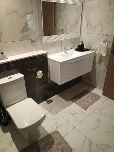 a bathroom with a white toilet and a sink at Chez Lina Folla in Monastir