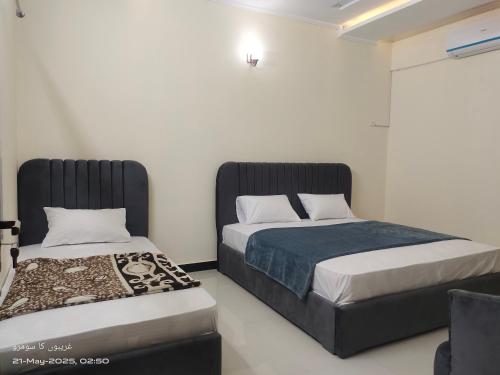 two beds sitting next to each other in a room at Islamabad Crest Villas in Islamabad