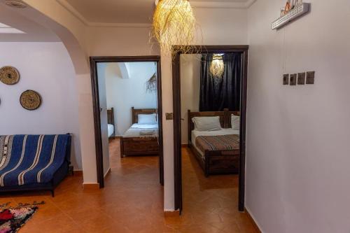 a room with a bedroom with a bed and a mirror at Hola Surf Morocco in Agadir