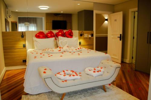 a bedroom with a bed with red pillows on it at Champet Boutique Hotel in Campos do Jordão