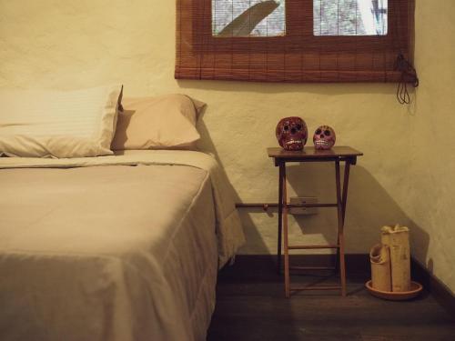 a bedroom with a bed and a table with two vases on it at Casa Nutabe - Habitación de campo cerca de Medellín in Girardota