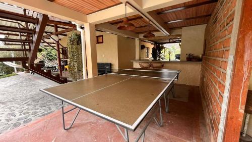 a ping pong table in a room with a brick wall at Casa Nutabe - Habitación de campo cerca de Medellín in Girardota