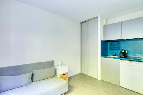 un salon avec un canapé et une cuisine dans l'établissement Nid Douillet à Caluire, 5 min de Lyon Centre, à Caluire-et-Cuire