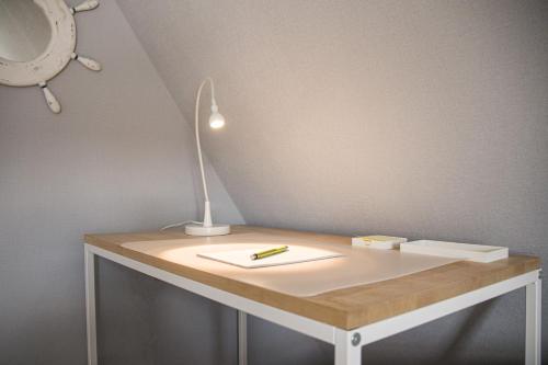a desk with a lamp and a pen on it at Haus Wattwurm in Midlum