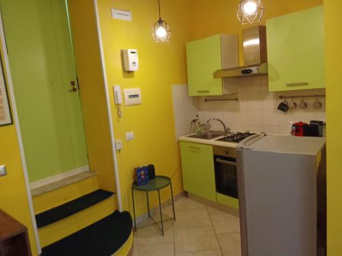 una pequeña cocina con armarios verdes y fregadero en Bonbon House, en Nápoles