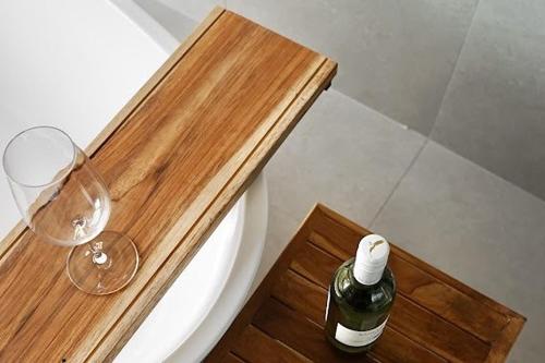 a bottle of wine and a glass on a wooden table at Mist Villa in Chiang Dao
