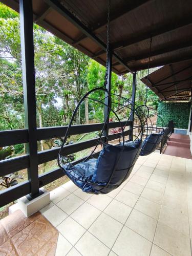 a porch with a hammock hanging from a roof at Ávita Lodge in Quesada