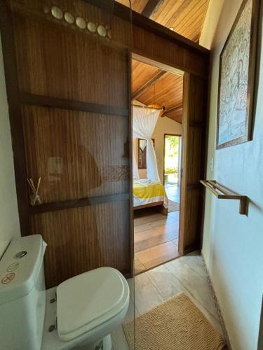 a bathroom with a toilet and a bedroom at Casa Del Mar in Marau