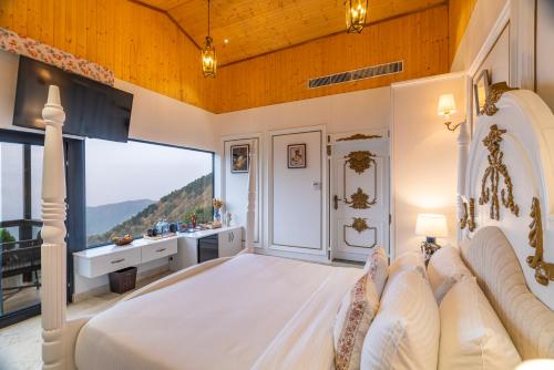 a bedroom with a large bed with a large window at The English Country House in Mussoorie