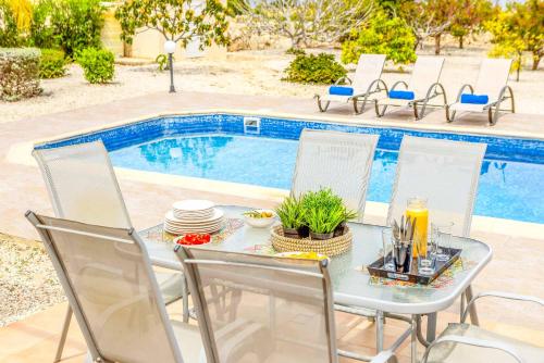 a table and chairs next to a swimming pool at Villa Lime Tree in Lachi