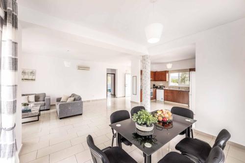 a dining room and living room with a table and chairs at Villa Lime Tree in Lachi