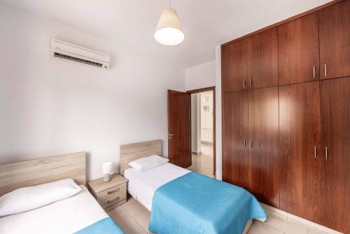 a bedroom with two beds and wooden cabinets at Villa Lime Tree in Lachi