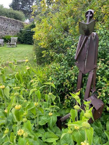 a garden with a bird feeder in a garden at Chambres d hôtes du Moulin à papier in Saint-Brieuc