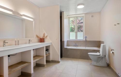 a bathroom with a toilet and a sink and a tub at Awesome Home In Haslev With Kitchen in Haslev