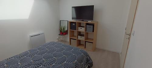une chambre avec un lit et une télévision à écran plat dans l'établissement Chambres d'hôtes à 20 min du circuit des 24H, à Beaufay