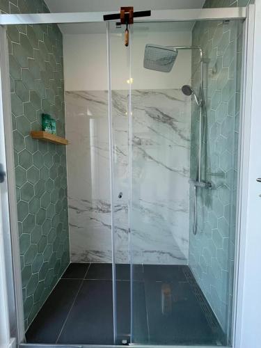 a shower with a glass door in a bathroom at GuestReady - Seaview Villa with Private Pool in Bretanha