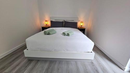 a bedroom with a white bed with two lamps on it at GuestReady - Seaview Villa with Private Pool in Bretanha