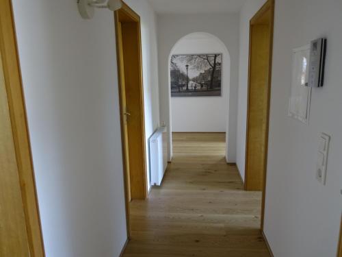 a hallway with an open door and a mirror at Ferienwohnung Mit Garten Im Schönen Tannheim in Tannheim