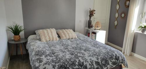 une chambre avec un lit avec deux oreillers dessus dans l'établissement Charmante maison de ville, au Mans