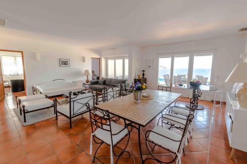 a living room with a table and chairs at Belle villa avec accès direct à la mer in Calvi