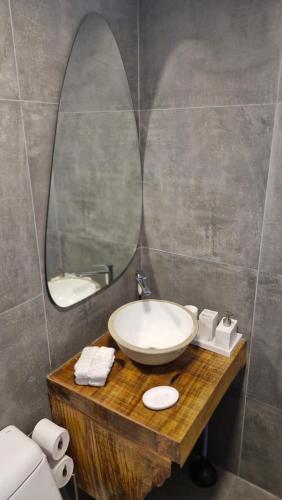 ein Badezimmer mit Waschbecken und Spiegel in der Unterkunft Refúgio Serra Lebre: Cabana Luxo Panorâmica em 6 Hectares de Araucárias in São Francisco de Paula