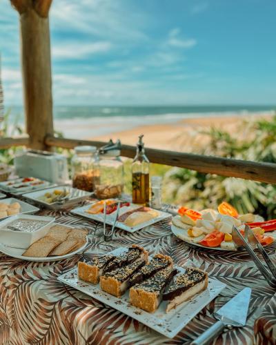 a table with plates of food on a beach at Casa Del Mar in Marau