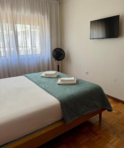 a bedroom with a bed with two towels on it at Madorninha Urban Nest in Porto